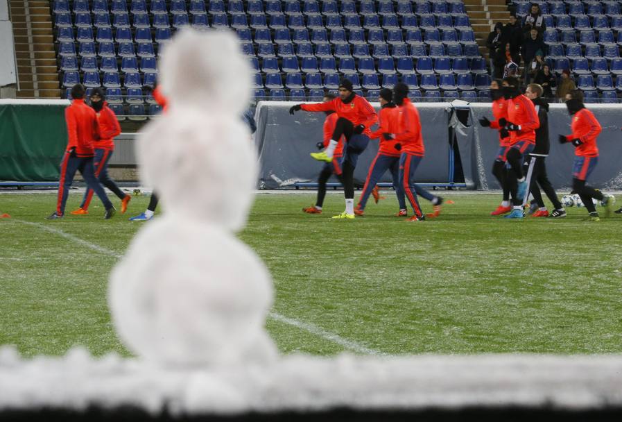 I giocatori del Valencia in allenamento sul campo gelato di San Pietroburgo: un piccolo pupazzo di neve in primo piano assiste allo spettacolo (Ap)